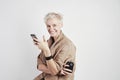 Portrait of blond caucasian woman smiling laughing emoticon drinks takeaway coffee, using smartphone on white background