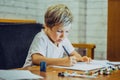 Portrait blond cute Preschool boy holding pen notebook look serious hard diligently diligently learn write, facial