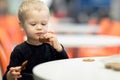 Little Boy Bites Cookies, Sitting At The Dinner Table. Horizontal Royalty Free Stock Photo
