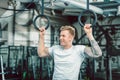 Handsome young man with strong arms hanging on gymnastic rings Royalty Free Stock Photo