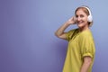 portrait of blond mature yo woman in big headphones on studio background with copy space Royalty Free Stock Photo