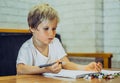 Portrait blond Preschool boy holding pen notebook look serious thoughtful think tired learn write, artistic facial