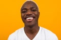 Portrait of a blond smiling charismatic african black man in a white t-shirt on a yellow studio background
