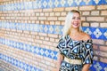 Portrait of blond woman in blue dress in front of colorful wall Royalty Free Stock Photo