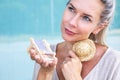 Blond woman holding miniature sun chair and looking longingly