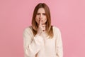 Woman keeping finger on lips making silence gesture, shushing asking to be quiet, secrecy concept. Royalty Free Stock Photo