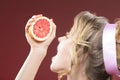 Portrait of Blond Woman Squeezing Grapefruit Half To Her Mouth. Royalty Free Stock Photo