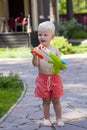 Portrait of blonde baby boy playing with water toy Royalty Free Stock Photo