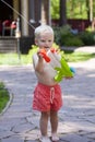 Portrait of blonde baby boy playing with water toy Royalty Free Stock Photo