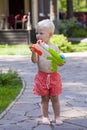 Portrait of blonde baby boy playing with water toy Royalty Free Stock Photo