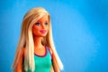 Portrait of blonde Barbie doll against blue background