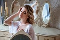 Portrait of blonde bride woman in a white lingerie sitting near mirror, fashion beauty portrait Royalty Free Stock Photo