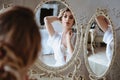 Portrait of blonde bride woman in a white lingerie sitting near mirror, fashion beauty portrait Royalty Free Stock Photo