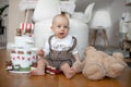 Portrait of blonde child. Indoors home child birthday party, baby with big blue eyes sitting on floor Royalty Free Stock Photo