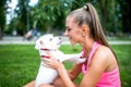 Portrait of blonde female playing with a little white dog, bichon