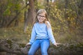 Portrait of a blonde girl with glasses outdoors in the park on the autumn park background Royalty Free Stock Photo