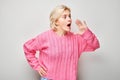 Portrait of blonde girl shouting loudly with hands, news, palms folded like megaphone Royalty Free Stock Photo