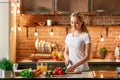 Cooking is really calming... Happy young woman cutting fresh vegetables in modern kitchen. Cozy interior Royalty Free Stock Photo