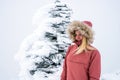 Portrait of blonde hiker girl with fur hooded jacket and backpack outdoors in the mountains