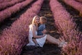 Portrait mother with little son are sitting in purple lavender field. Concept of allergy, travel