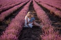 Portrait mother with little son are sitting in purple lavender field. Concept of allergy, travel