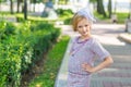 Portrait of a blonde in pink attire in a park outdoors.