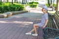 Portrait of a blonde in pink attire in a park outdoors.