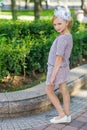 Portrait of a blonde in pink attire in a park outdoors.