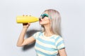 Portrait of blonde pretty girl drinking water from metal thermo bottle on white. Royalty Free Stock Photo