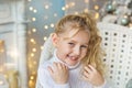 Portrait of blonde pretty little girl very smiles in sweater in Christmas