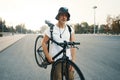 Portrait of a blonde white man in the city with a classic bike o