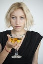 Blonde Young Woman with Beautiful Blue Eyes Drinks a Martini Royalty Free Stock Photo