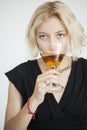 Blonde Young Woman with Beautiful Blue Eyes Drinks a Martini Royalty Free Stock Photo