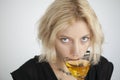 Blonde Young Woman with Beautiful Blue Eyes Drinks a Martini Royalty Free Stock Photo