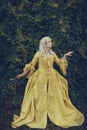 Portrait of blonde woman dressed in historical Baroque clothes with old fashion hairstyle, outdoors