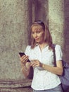 Portrait of blondie girl using phone with headhpones outdoors. Royalty Free Stock Photo