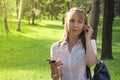 Portrait of blondie girl using phone with headhpones outdoors Royalty Free Stock Photo