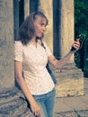 Portrait of blondie girl using phone with headhpones outdoors. Royalty Free Stock Photo