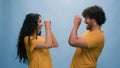 Portrait in blue background studio funny couple Indian man Arabian woman Hispanic friends girl guy having fun looking Royalty Free Stock Photo