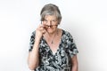 Portrait of angry senior woman peering over her eyeglasses on white background studio shot Royalty Free Stock Photo