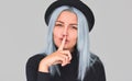 Portrait of blue hair female wears black clothes, shows silence sign, asks to keep information confidential, has pretty expression Royalty Free Stock Photo