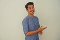 Portrait of a blue shirt young Asian smile face and beard guy standing confidently with his arms crossed against a white wall Royalty Free Stock Photo