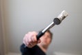 A portrait of a blurred person in the background holding a hammer in his hand towards the camera like he is hammering on something Royalty Free Stock Photo