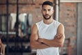 Portrait of bodybuilder with attitude in the gym. Young bodybuilder with arms crossed in the gym. Cool, fit man standing