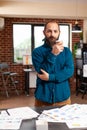 Portrait of bookkeeper man holding cup of coffee standing in startup company office