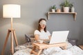Portrait of bore unrecognizable woman wearing sleeping mask on her eyes having break while working on laptop from home and Royalty Free Stock Photo