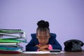 Portrait of bored businesswoman leaning by files and telephone