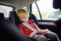 Portrait of a bored little boy sitting in a car seat. Safety of children Royalty Free Stock Photo