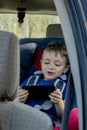 Portrait of a bored little boy sitting in a car seat. Safety of transportation of children