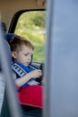 Portrait of a bored little boy sitting in a car seat. Safety of transportation of children Royalty Free Stock Photo